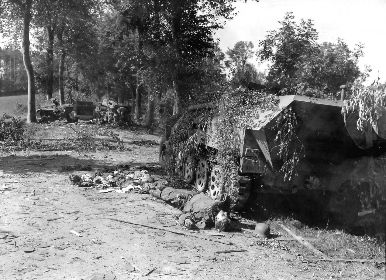 Mortain - Cadavre d'un soldat allemand au pied d'un semi-chenillé Sdkfz 251