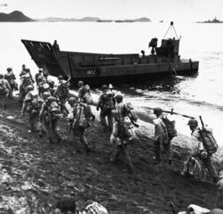 Troops marching up beach during _loading for Kiska operation 13 August 1943