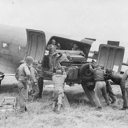 Members of Ninth Troop Carrier Command unload a jeep from a Douglas C-47 (...)