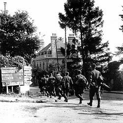 PRISONNIERS ALLEMANDS MARCHANT DANS DOMFRONT LE 14 AOUT 1944