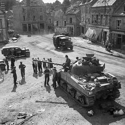 A Sherman Firefly and other vehicles in the village of Putanges, 20 August 1944