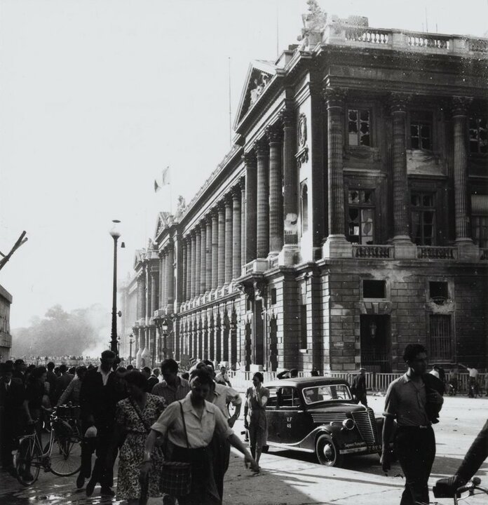 Ambulance de la Wehrmacht-Heer arrêtée sur le trottoir de la rue de Rivoli, alors que la fumée d'un incendie monte du Ministère de la Marine