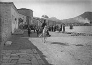 Des bandits musulmans défilant avec du butin à Phocée (aujourd'hui Foça, Turquie) le 13 juin 1914. En arrière-plan, des réfugiés grecs et des bâtiments en feu.