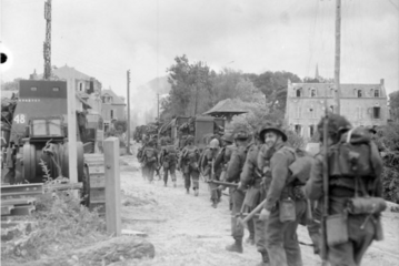 Infantrymen of Le Régiment de la Chaudière moving through Bernières-sur-Mer, France, 6 June 1944
